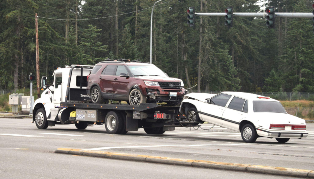 This photo shows a tow truck towing a car on the road.