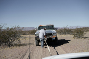 This photo shows a man towing a pick-up truck.